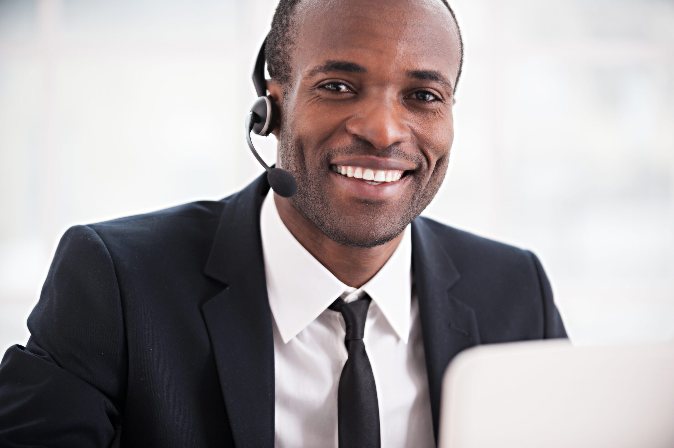 Customer Service Representative. Cheerful Young African Man In Formalwear And Headset Working On Laptop And Smiling At Camera